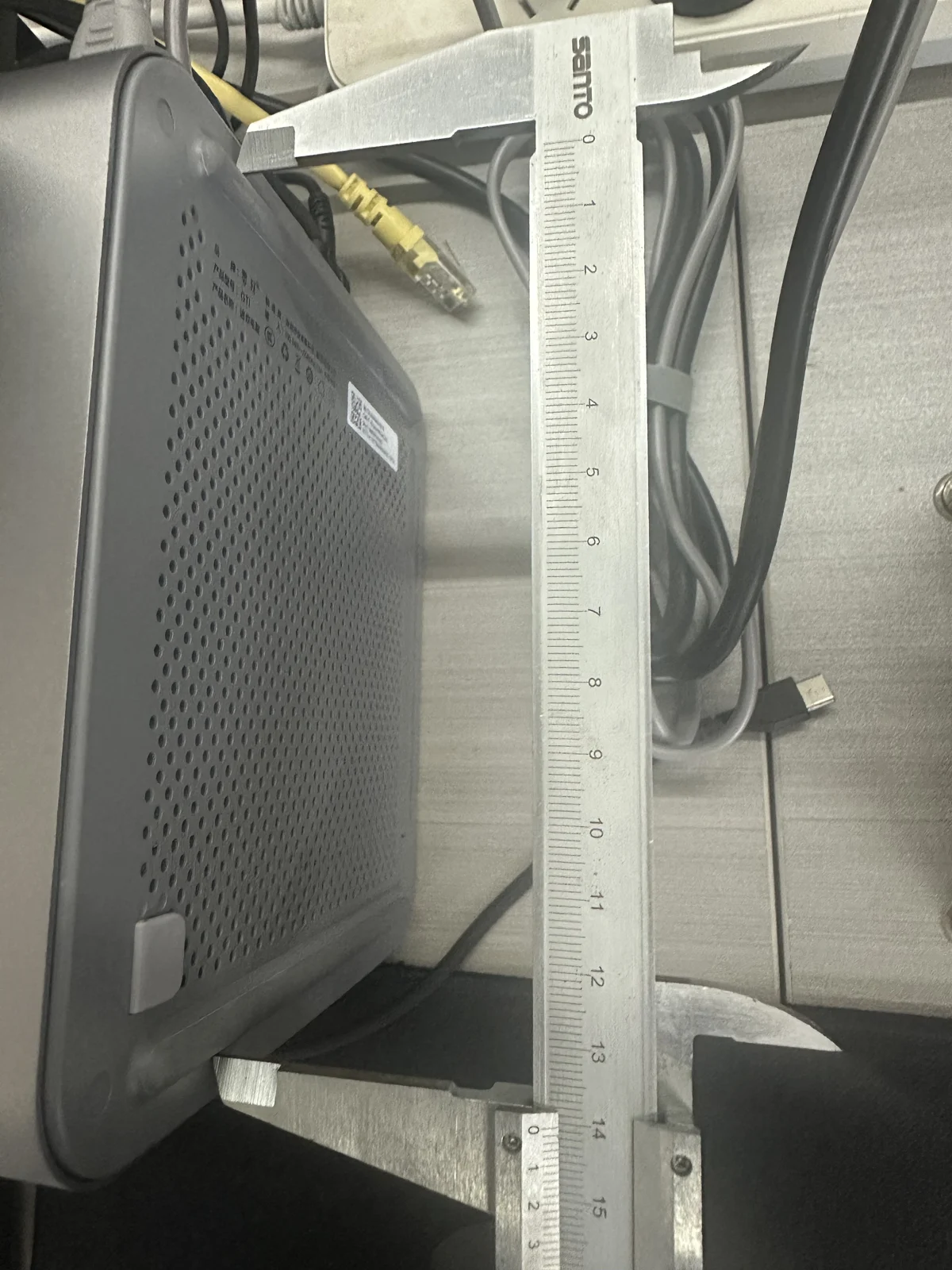 卡尺跨过 GTi13 底部两处脚垫,测量两脚垫的外侧跨度